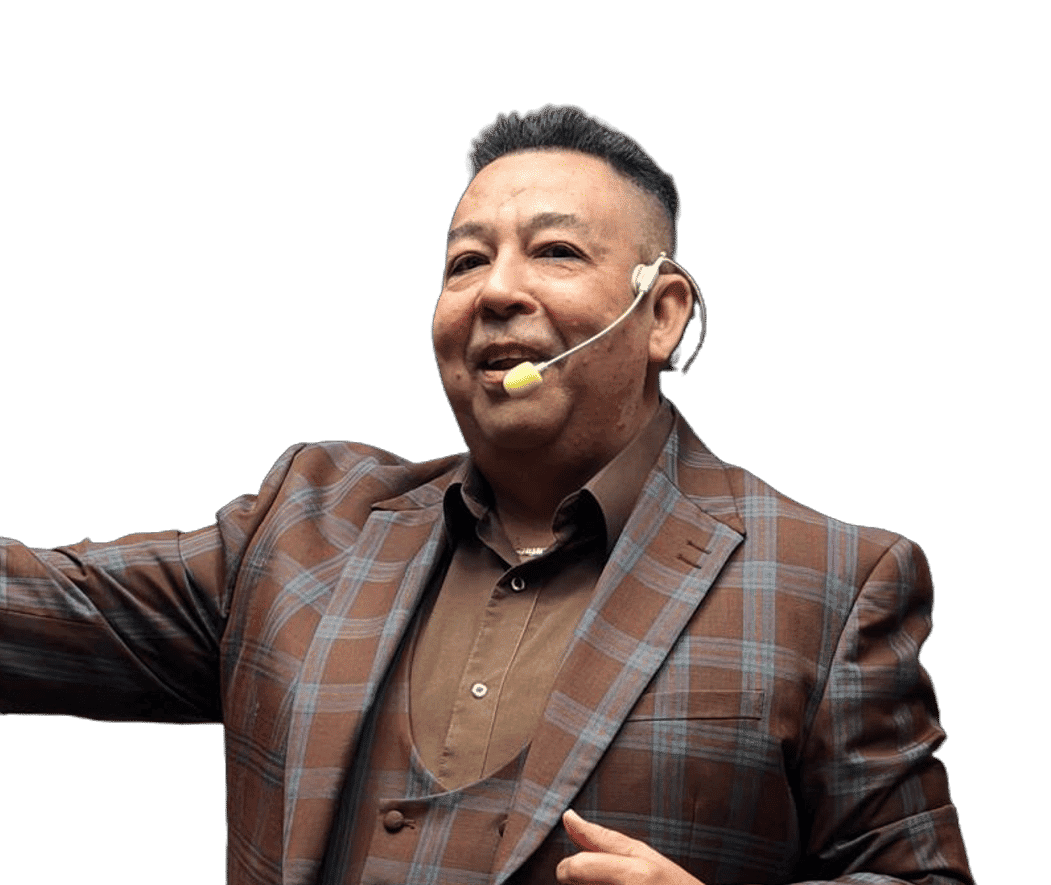 Man in plaid suit speaking with a headset and gesturing during a presentation.